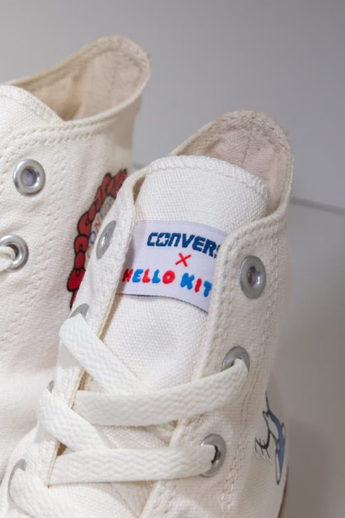 La nouvelle Converse Hello Kitty de 2023, de couleur blanche, avec sa languette Converse x Hello Kitty.