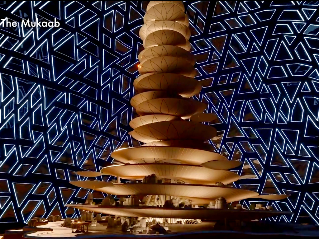 L'immense tour érigée à l'intérieur du Mukaab, entourée d'un écran géant diffusant un motif géométrique.